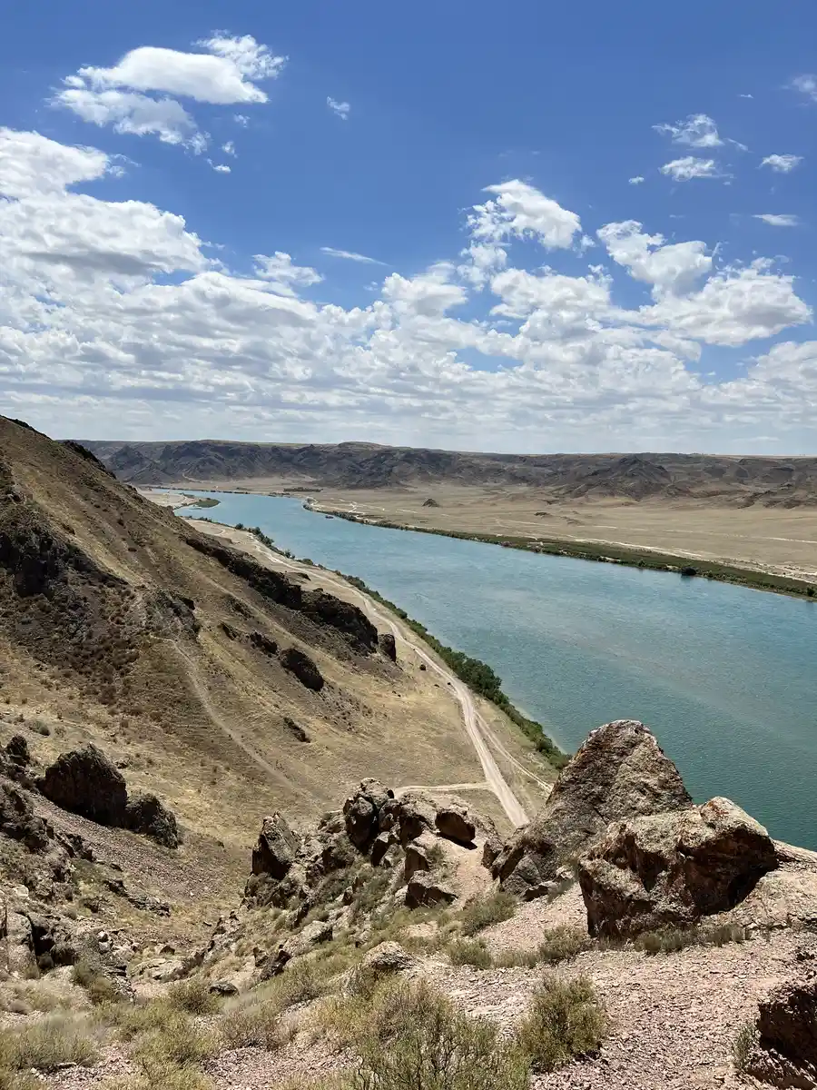 View from a cliff over the Ili River canyon with a hiking trail along the ridge